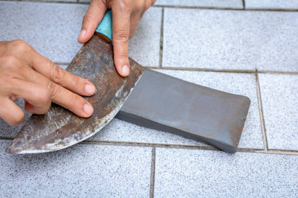 istock close up hand with Knife sharpener on rock 696615300