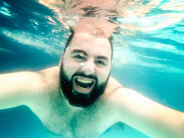 młody człowiek relaksujący się w basenie - underwater mine zdjęcia i obrazy z banku zdjęć