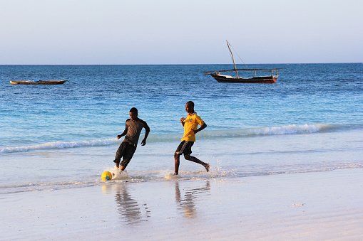Zanzibar, Tanzania - January 4, 2016: A game of football on the beach at sunset in Nungwi. Zanzibar, Tanzania