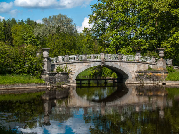istock Stone bridge on the lake in the park in summer 696640052