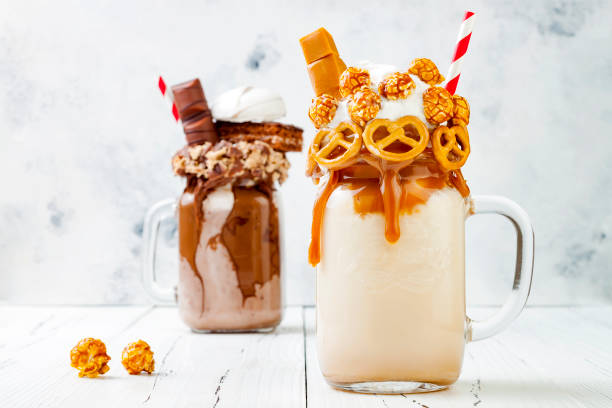 istock Caramel and chocolate indulgent exreme milkshakes with brezel waffles, popcorn, marshmallow, ice cream and whipped cream. Crazy freakshake food trend. 696651200