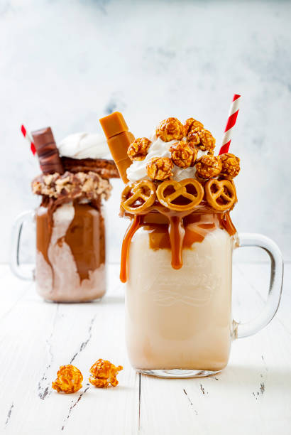 istock Caramel and chocolate indulgent exreme milkshakes with brezel waffles, popcorn, marshmallow, ice cream and whipped cream. Crazy freakshake food trend. 696651234