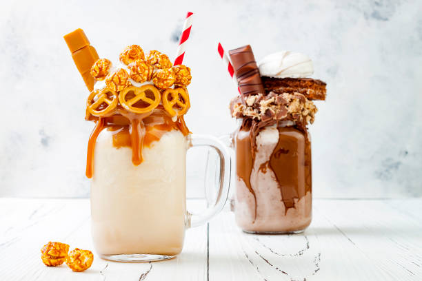 istock Caramel and chocolate indulgent exreme milkshakes with brezel waffles, popcorn, marshmallow, ice cream and whipped cream. Crazy freakshake food trend. 696651836