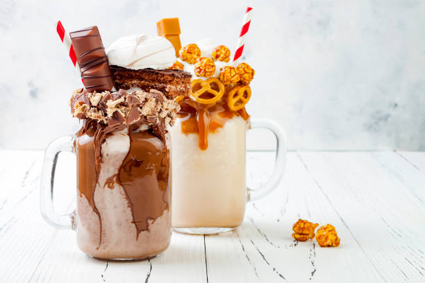 istock Caramel and chocolate indulgent exreme milkshakes with brezel waffles, popcorn, marshmallow, ice cream and whipped cream. Crazy freakshake food trend. 696653270
