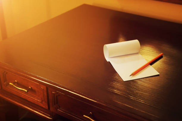 Pencil and blank note paper on old wood table, Creative work, writing, drawing concept. vintage toned with warm light flare image.