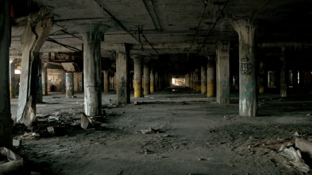 CLOSE UP: Concrete pillars in rows in abandoned decaying underground parking lot