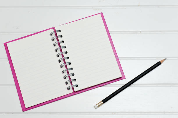 istock note book on a white wooden floor. 696666848