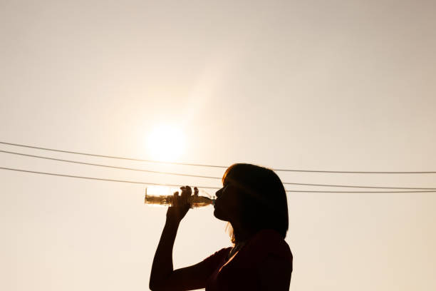 istock Female drinking water in hot summer - heat stroke concept. 696669882