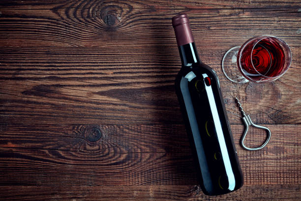 Bottle and glass of red wine Bottle and glass of red wine on wooden background from top view shiraz stock pictures, royalty-free photos & images