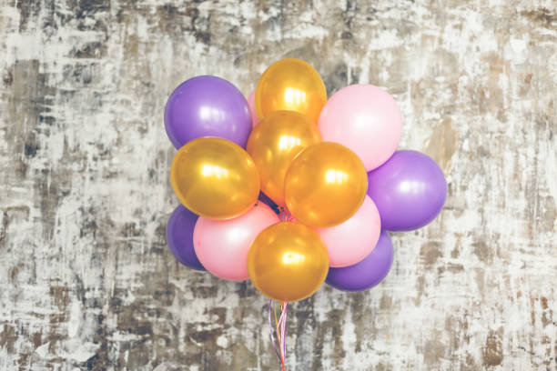 istock Bright balloons bunch against a textured wall 696682916