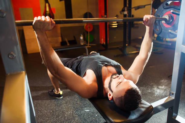 istock Young Man In Gym Exercising Chest On The Bench Press 696683942