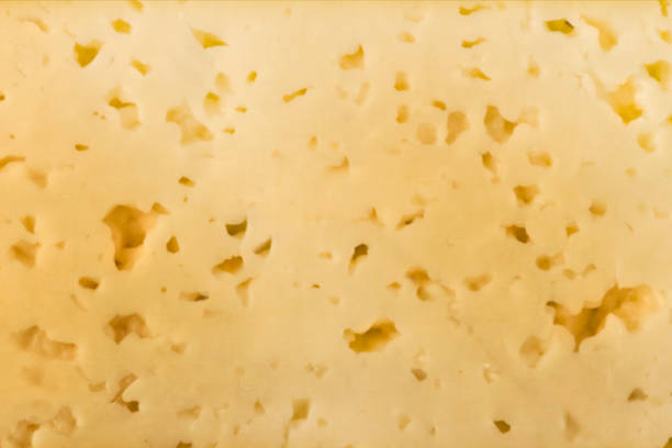 istock Texture of yellow cheese with small holes 696689812