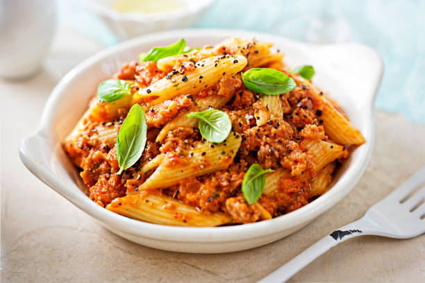 italienische toskanische wurst penne in tomatensauce mit basilikum - penne rigatoni pasta tomato pasta stock-fotos und bilder