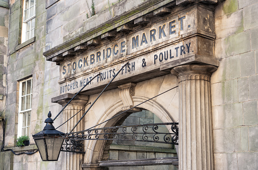 An old sign over an archway in the Stockbridge district of Edinburgh, for an old meat, fruits, fish and poultry market.  A modern weekend community market continues at a nearby site.