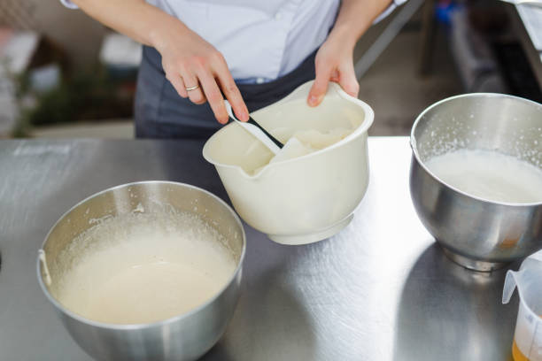 istock Woman in white uniform prepares food 696737342