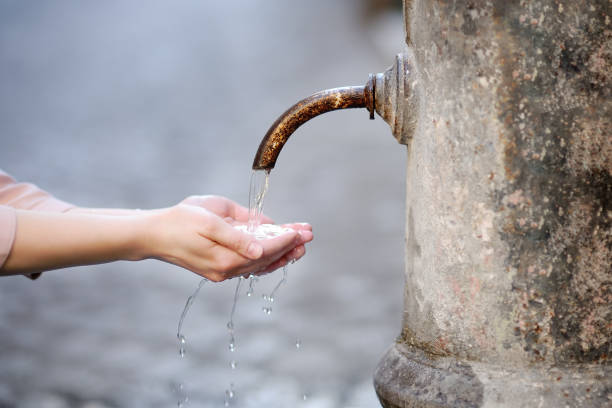 Woman washing hands in a city fountain in Rome, Italy Closeup photo of woman washing hands in a city fountain. Young woman drinking clean water from the fountain in Rome, Italy whites only drinking fountain stock pictures, royalty-free photos & images