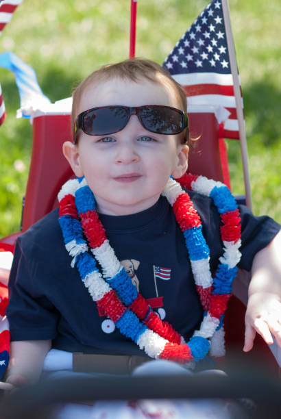 istock Young boy riding in red wagon having fun in the park for July Fourth 696763170