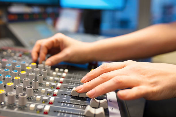 istock Female Radio Host Using Music Mixer In Studio 696763410