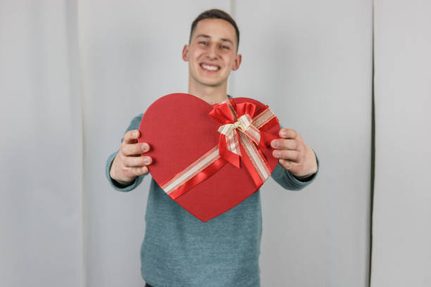 istock Pretty young boy holding a gift heart. 696763540