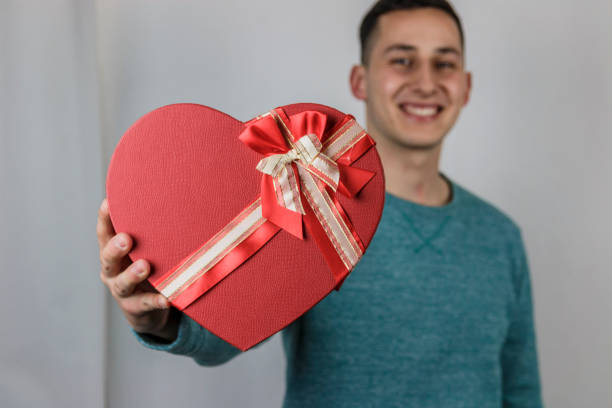 istock Pretty young boy holding a gift heart. 696763562