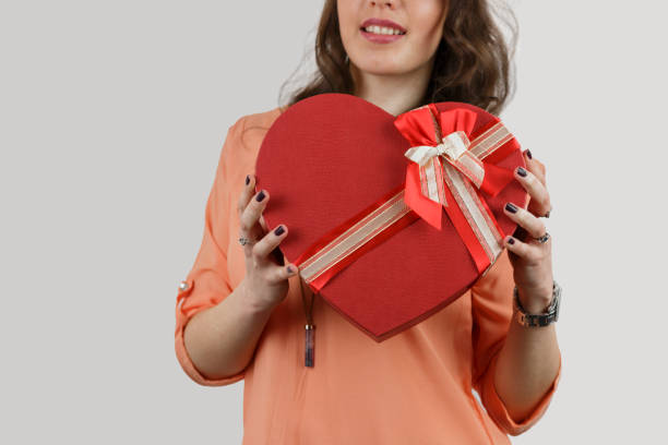 istock Pretty young girl holding a gift heart. 696764084