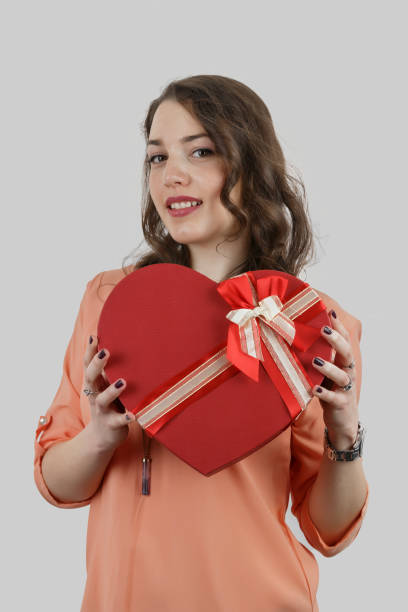 istock Pretty young girl holding a gift heart. 696764100