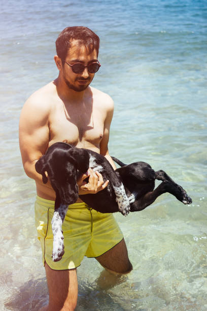 istock Man playing with his dog on the beach 696764358