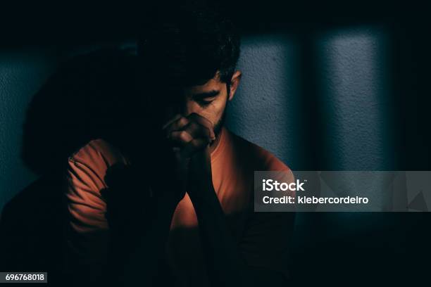Prisoner Man In Dark Cell Depressed Or Praying Stock Photo - Download Image Now - Praying, Prison, Men