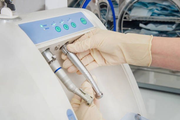 istock Instrument sterilization and cleaning in dentistry, using automatic instrument maintenance equipment to clean turbines and handpieces, closeup shoot. 696770108