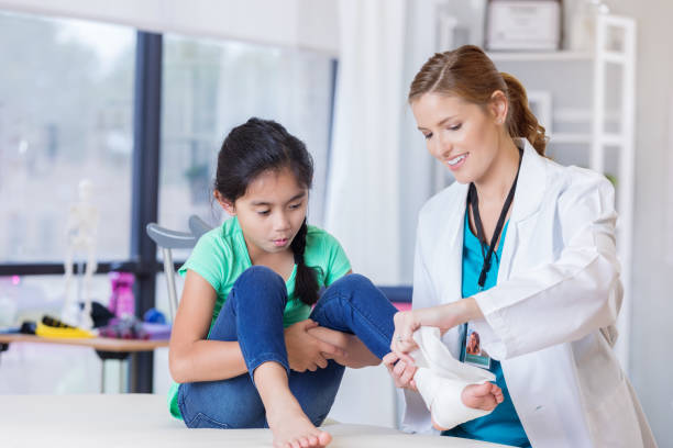 istock Emergency room doctor wraps young patient's ankle 696792476