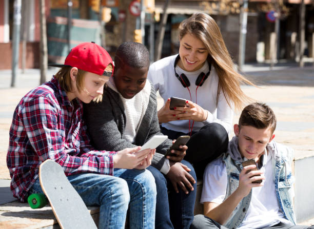 istock Happy teens playing on smarthphones 696793892