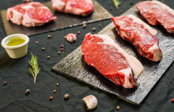 istock Beef cow steak meat with spices and herbs against black background 696796878