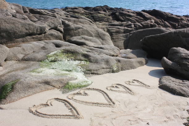 istock Drawings of hearts on sand 696800020