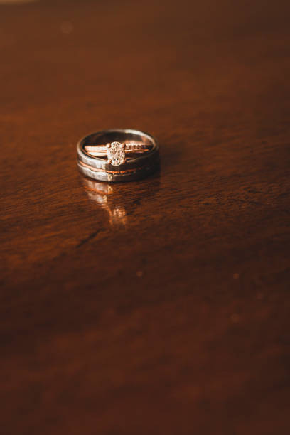 istock Rose Gold Wedding Ring and Obsidian Wedding Ring on Wood 696800092