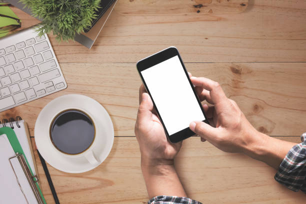 istock Man holding smart phone on top view workspace desk with copy space 696806528