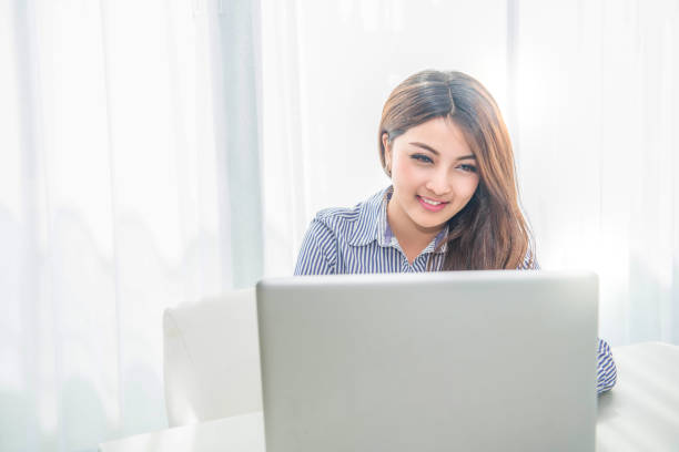istock Beautiful young asian woman using laptop 696807444