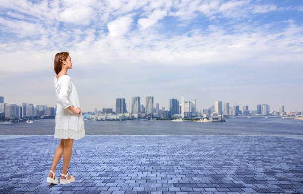 young girl standing on an observation platform and modern cityscape panorama