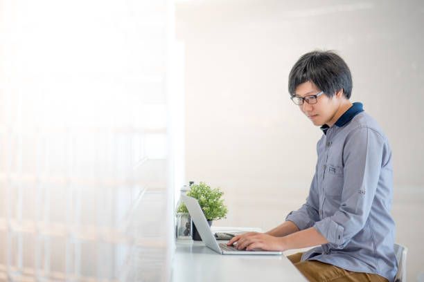 istock Young Asian man working with laptop in cafe 696816802