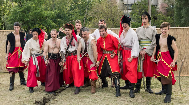 a group of young men in suits of cossacks of zaporizhzhya sich a war cry is very emotional during the reconstruction of the medieval battle. dnipro, ukraine. 20th may 2017. - history knight historical reenactment military imagens e fotografias de stock