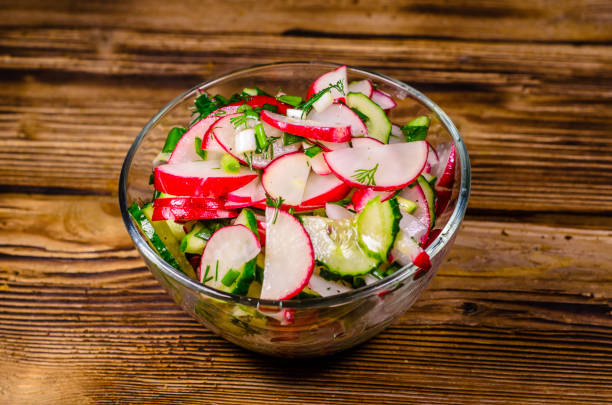 Vegetarian salad with radish and cucumbers in glass bowl