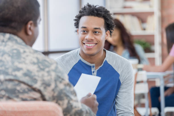istock Smiling young man talks with military officer 696824436