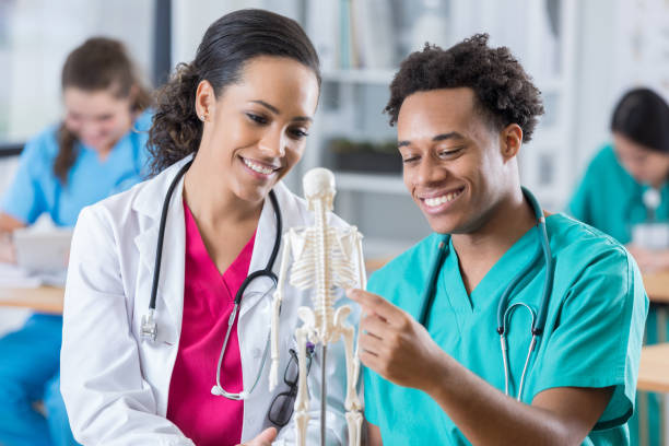 istock Medical intern analyzes model of human skeleton 696824498