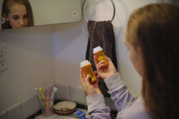 niña encuentra medicamentos recetados en baño - armario de aseo personal fotografías e imágenes de stock
