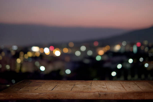 Empty rustic wood table with city night background.