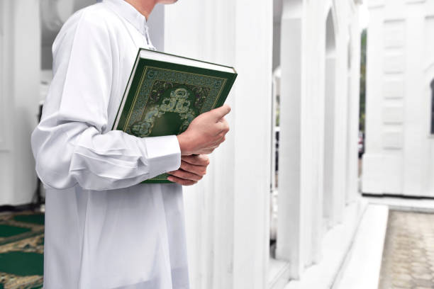 istock Muslim man hands holding the Koran 696834962