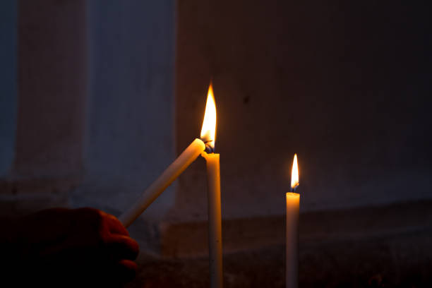 eine kirche kerze anzünden; dunklen hintergrund - lighted candle stock-fotos und bilder