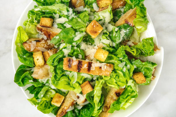 крупным планом салат из курицы цезарь на белом мраморном столе - grilled chicken salad salad dressing food стоковые фото и изображения