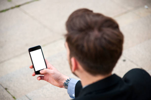 istock Young businessman using smart phone with blank screen outdoors 696850654