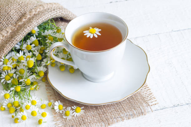 istock Chamomile tea on white wooden background 696853304