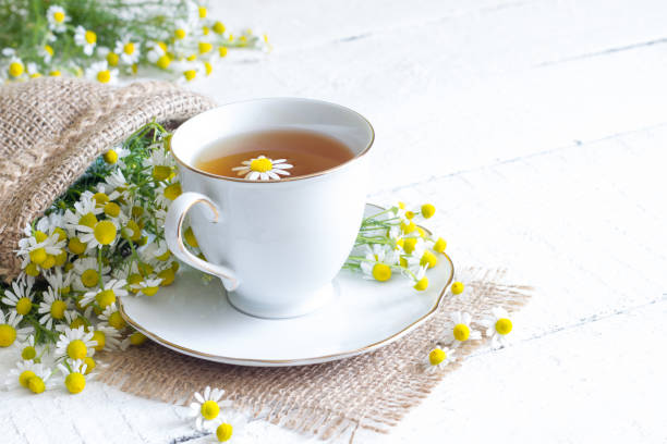 istock Chamomile tea on white wooden background 696853314